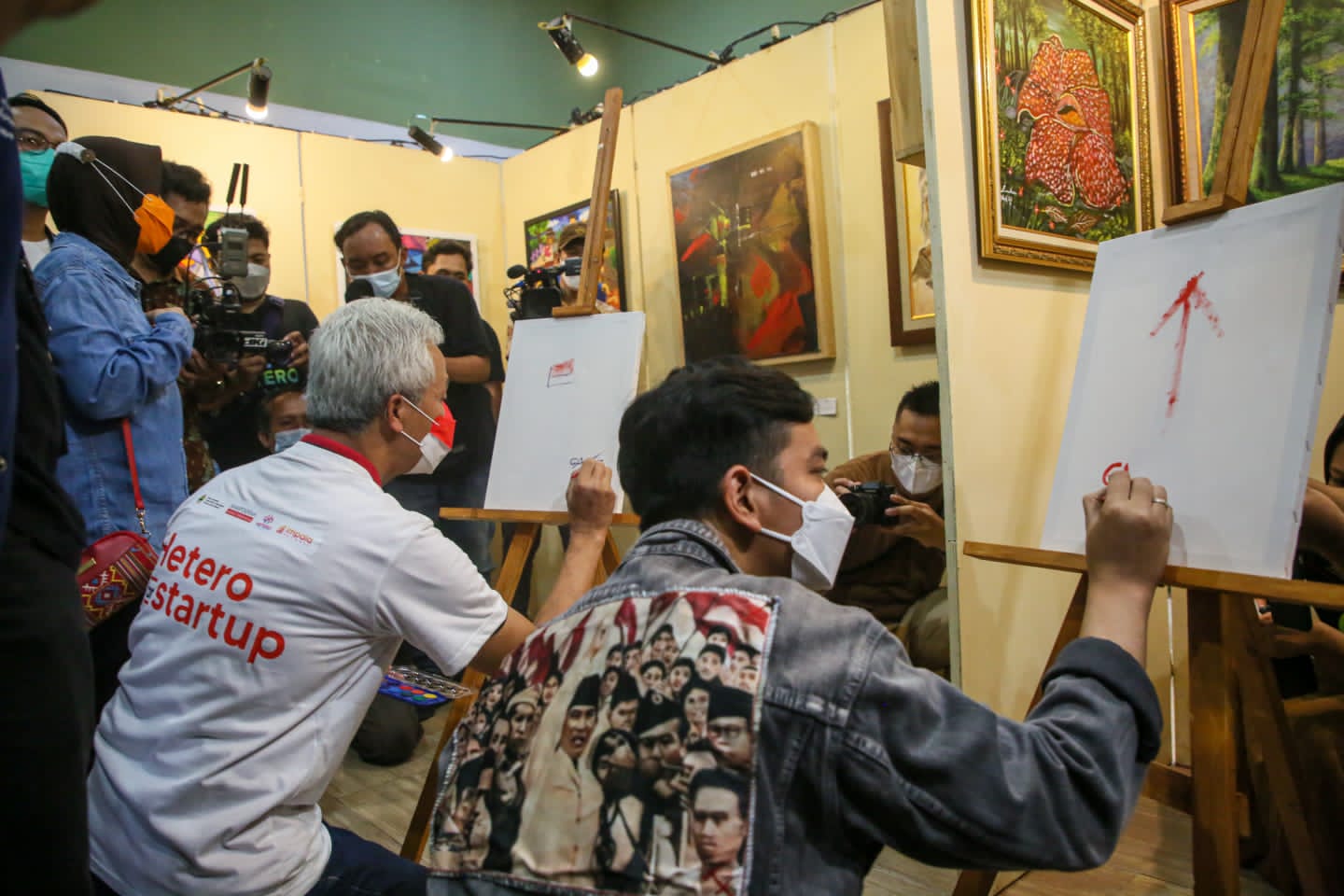 Gubernur Jateng, Ganjar Pranowo dan Wali Kota Surakarta, Gibran Rakabuming saat berpartisipasi dalam kegiatan melukis di salah satu studio Hetero Space. Foto: jatengprov.go.id