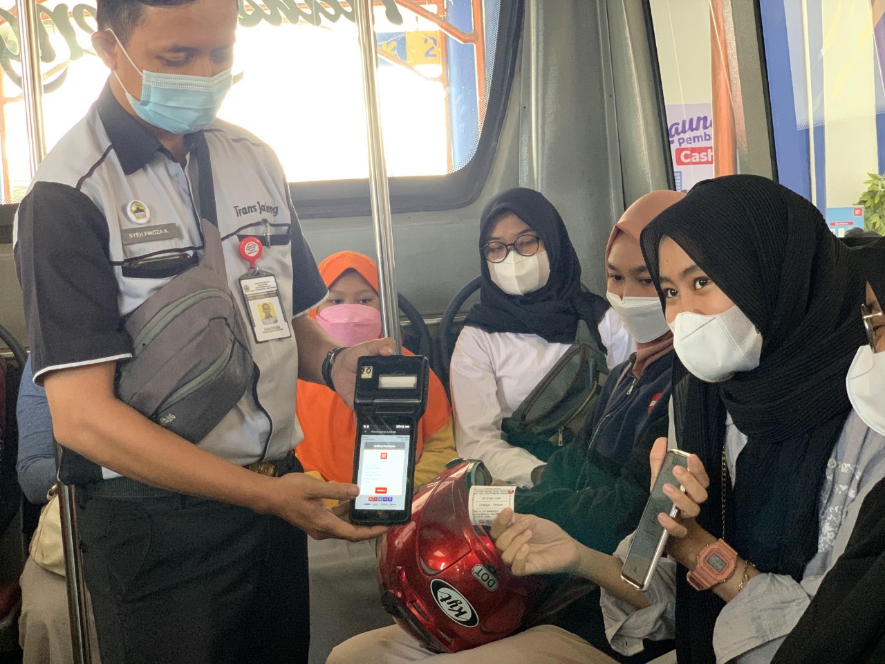 Petugas Trans Jateng saat memberikan QRIS untuk penumpang membayar nontunai. Foto: jatengprov.go.id
