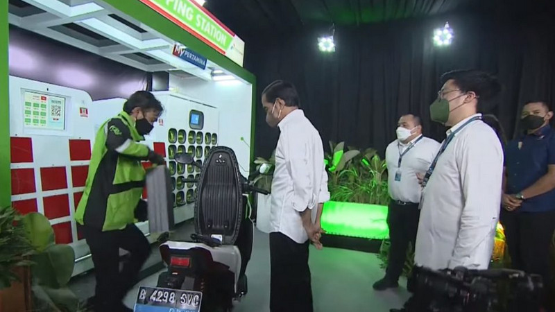 Presiden Joko Widodo (tengah) saat meninjau proses pergantian baterai motor listrik di sela-sela peluncuran ekosistem kendaraan listrik di Jakarta. Foto: Tangkapan layar kanal YouTube Sekretariat Kabinet RI