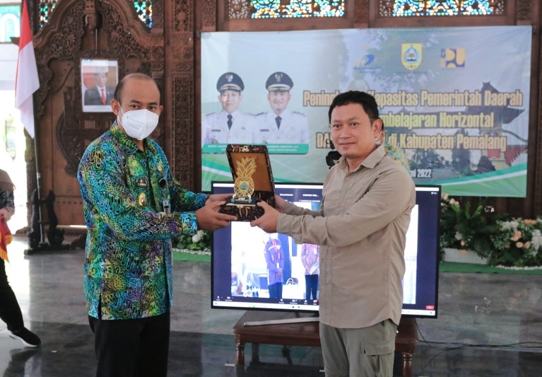 Bupati Pemalang, Mukti Agung Wibowo, saat menyerahkan cendera mata saat menghadiri Sosialisasi Peningkatan Kapasitas Pemerintah Daerah melalui Pembelajaran Horizontal Dana Alokasi Khusus (DAK) Integrasi. (Foto: pemalangkab.go.id)